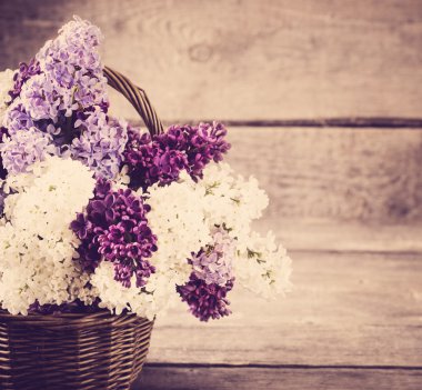 sepet ve ahşap arka plan üzerinde Lila çiçek şube