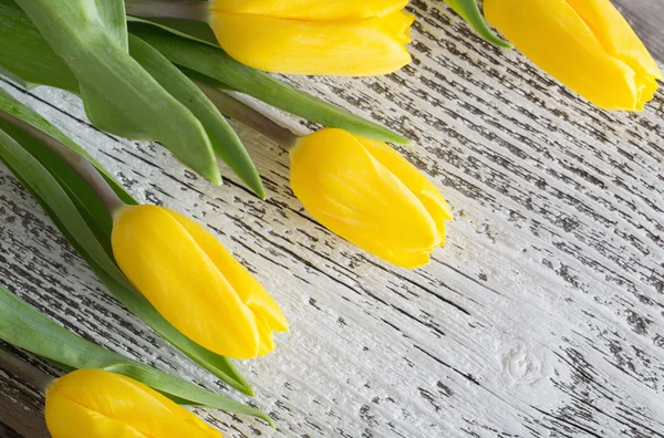 Yellow tulips over wooden background — Stock Photo, Image