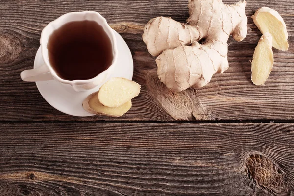 Té de jengibre en una taza blanca sobre fondo de madera — Foto de Stock