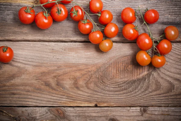 Tomates cereja no fundo de madeira rústica — Fotografia de Stock