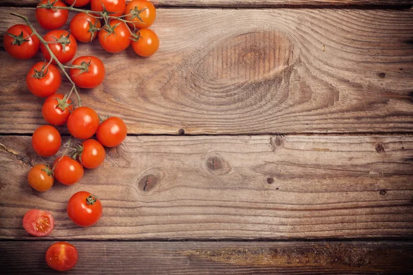 Tomates cereja no fundo de madeira rústica — Fotografia de Stock