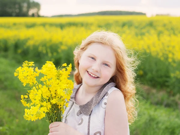 Happy girl in rape field — Stock Photo, Image