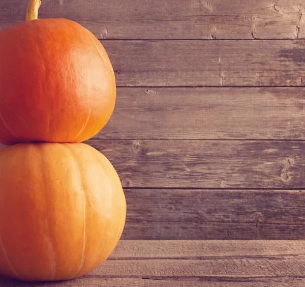 Three pumpkins on wooden background — Stock Photo, Image