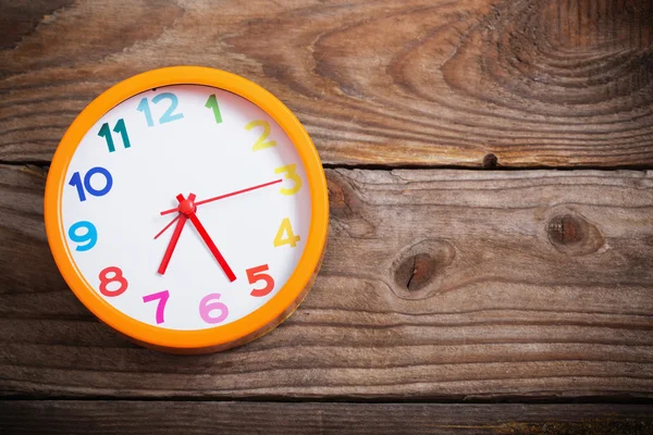 Reloj despertador moderno con colorido número sobre fondo de madera —  Fotos de Stock