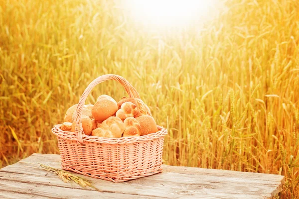 Pastries in a basket on a wooden table outdoor — Stock Photo, Image