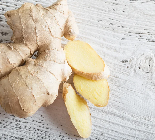 Ginger root sliced on wooden background — Stock Photo, Image