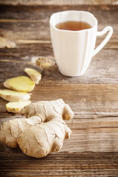 Chá de gengibre em uma xícara branca no fundo de madeira — Fotografia de Stock