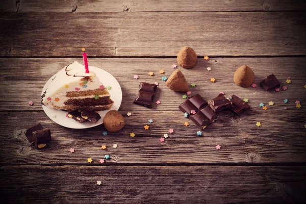 Peça de bolo de aniversário em fundo de madeira — Fotografia de Stock