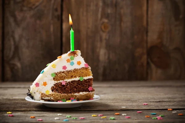 Kawałek tortu urodzinowego na drewniane tła — Zdjęcie stockowe