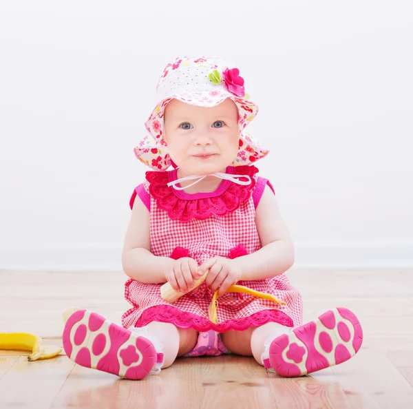 Little girl with banana indoor — Stock Photo, Image