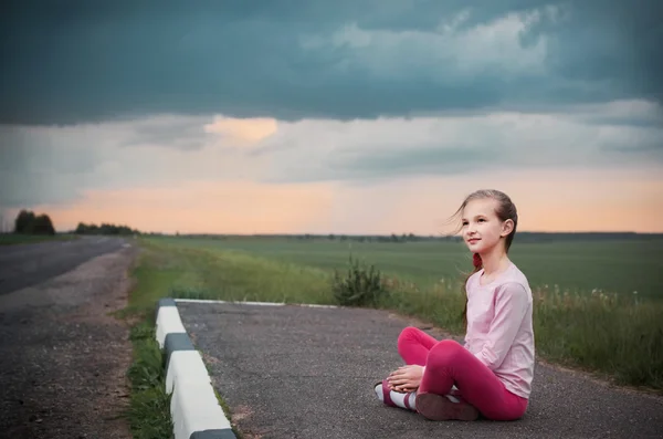 Beautiful girl sitting at road — Stock Photo, Image