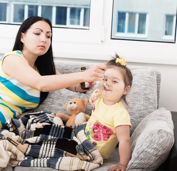 Mutter gießt leckeren Sirup ein, um den Husten ihres kleinen Mädchens zu lindern — Stockfoto