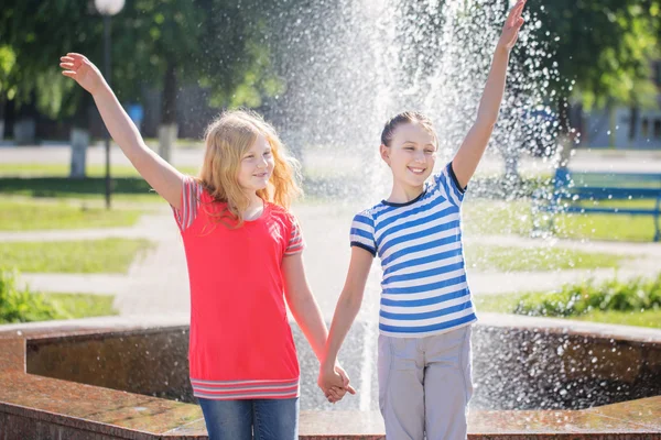 Дві щасливі дівчата біля фонтану — стокове фото