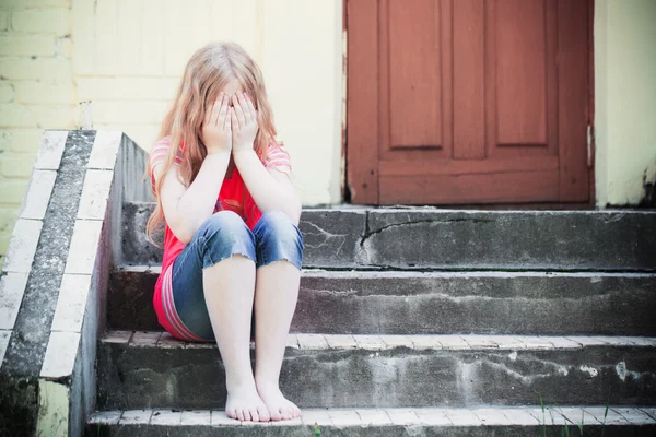 Retrato de menina triste sentado perto da parede — Fotografia de Stock