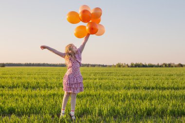 Açık turuncu balonlarla mutlu kız
