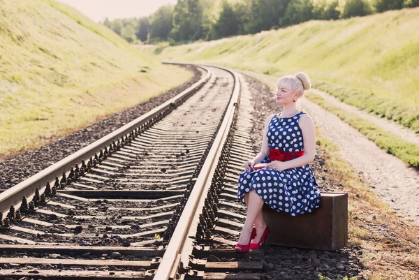 Μόδα κορίτσι με τη βαλίτσα στο σιδηροδρόμων — Φωτογραφία Αρχείου
