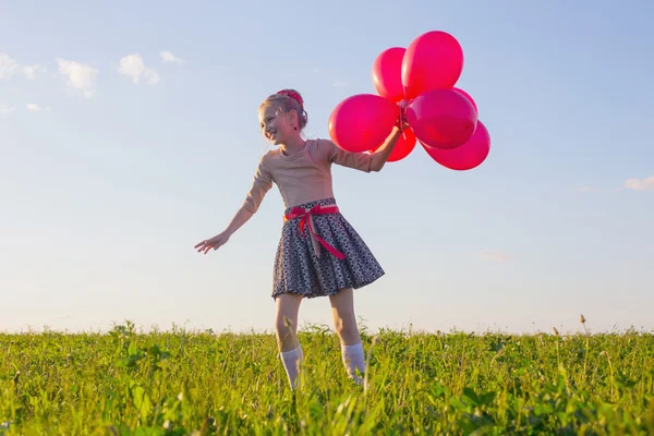 Glad tjej med röda ballonger utomhus — Stockfoto