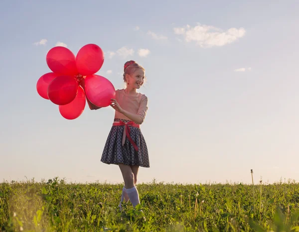 Glad tjej med röda ballonger utomhus — Stockfoto