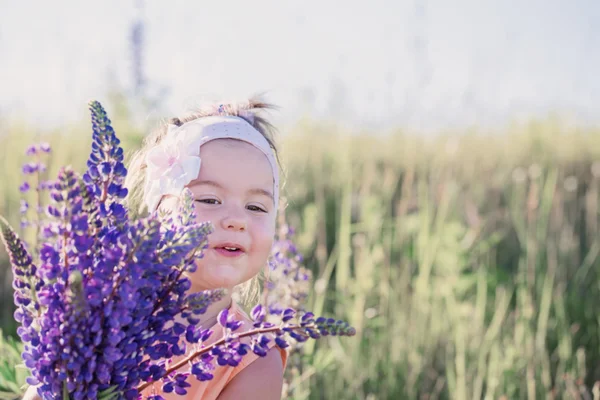 Liten flicka med blommor utomhus — Stockfoto