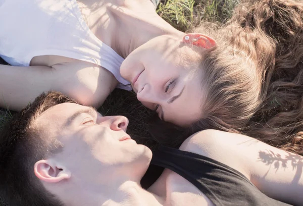 Jovem casal relaxante no gramado em um parque de verão — Fotografia de Stock