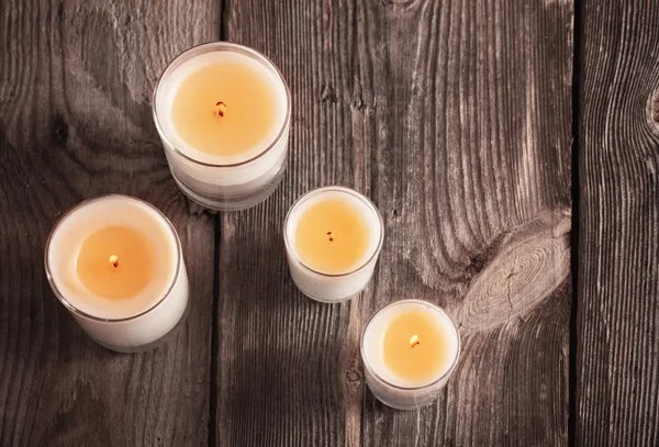 Scented candles on old wooden background — Stock Photo, Image