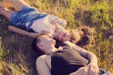 Genç çift rahatlatıcı bir yaz Park'ın bahçesinde