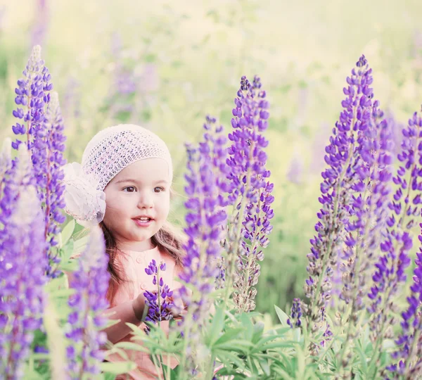 Liten flicka med blommor utomhus — Stockfoto