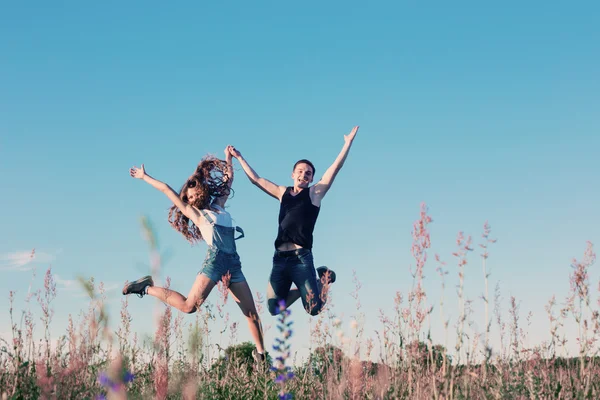 Jeune couple heureux sautant en plein air — Photo