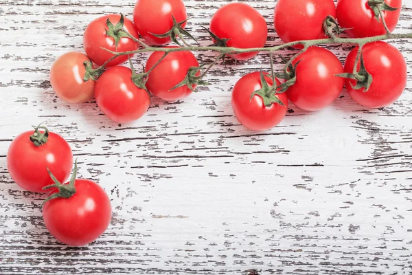 Cherry tomatoes on rustic wooden background — Stock Photo, Image