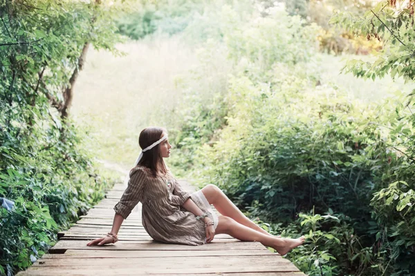 Menina bonita na velha ponte de madeira na floresta — Fotografia de Stock