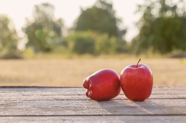 Rode appel op tafel buiten — Stockfoto