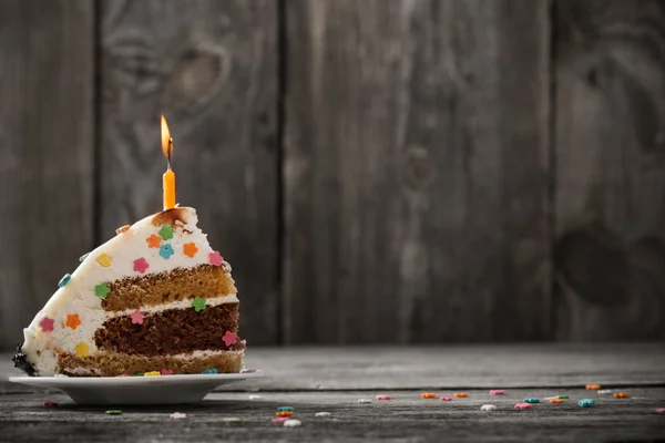 Pedazo de pastel de cumpleaños sobre fondo de madera — Foto de Stock