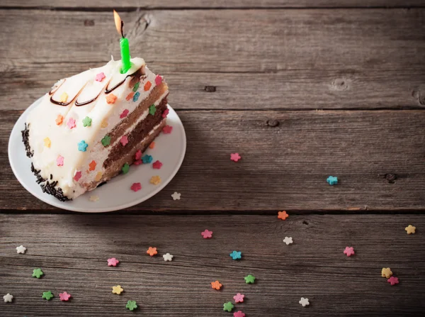 Peça de bolo de aniversário em fundo de madeira — Fotografia de Stock