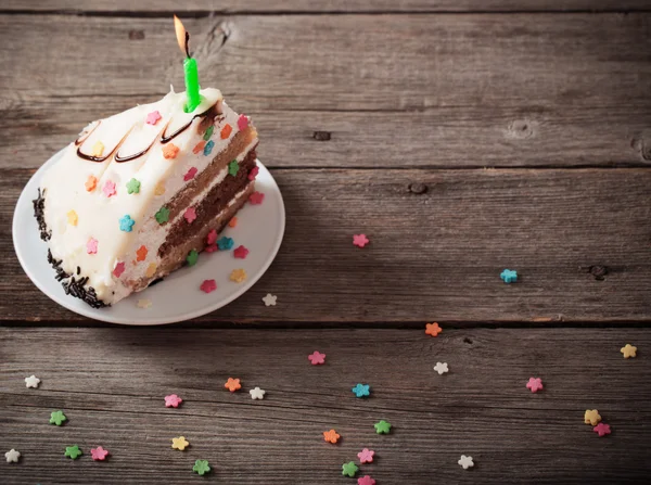 Pièce de gâteau d'anniversaire sur fond en bois — Photo