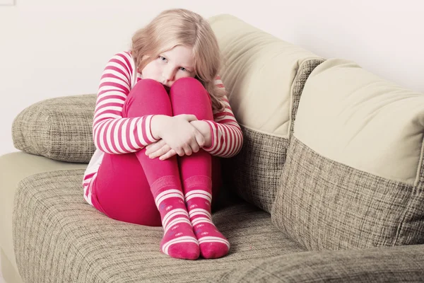 Menina triste no sofá — Fotografia de Stock