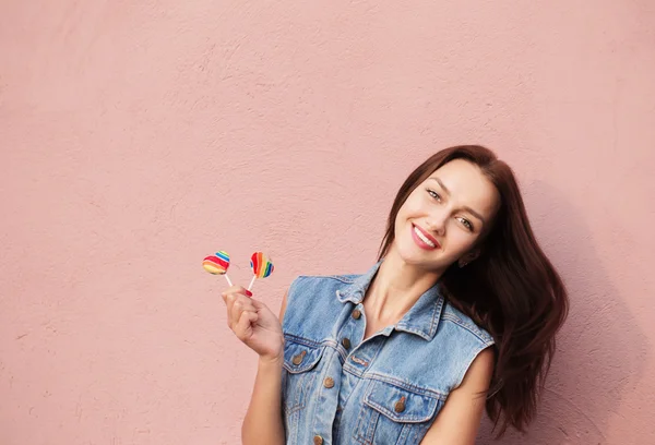 Happy girl with candy on background wall — Stock Photo, Image