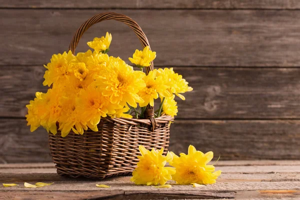 Blommor i korg på trä bakgrund — Stockfoto