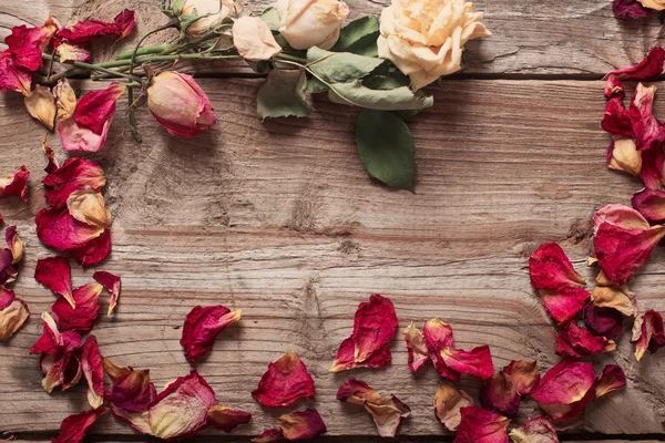 Сушені пелюстки троянд на дерев'яному столі — стокове фото