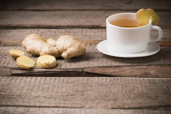 Thé au gingembre dans une tasse blanche sur fond bois — Photo