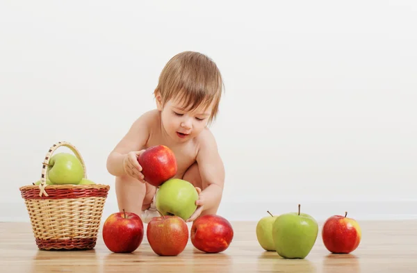 Porträt eines niedlichen kleinen Kindes mit Äpfeln drinnen — Stockfoto