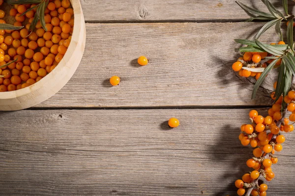 Sanddornbeeren auf einem hölzernen Hintergrund — Stockfoto