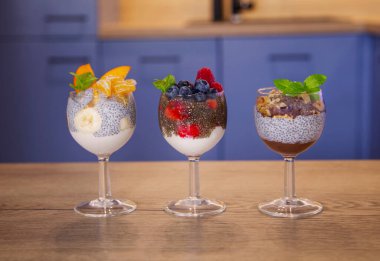 Mavi bir mutfakta böğürtlenli puding ve yoğurt.