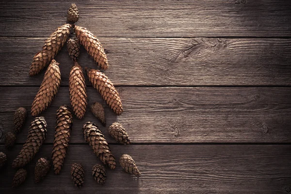 Cones in the form of a Christmas tree on a wooden background — Stock Photo, Image