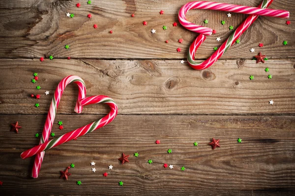 Bastoncini di zucchero come cuore su tavola di legno — Foto Stock