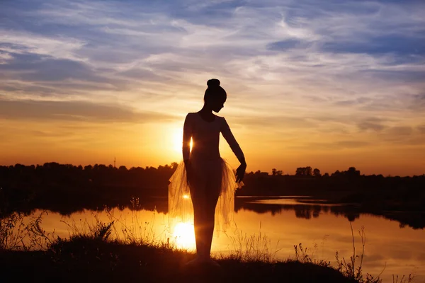 Silueta baletní tanečnice při západu slunce venku — Stock fotografie
