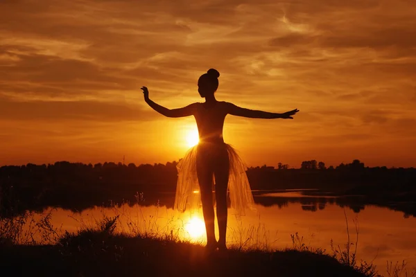 Silhueta de uma dançarina de balé ao pôr-do-sol ao ar livre — Fotografia de Stock