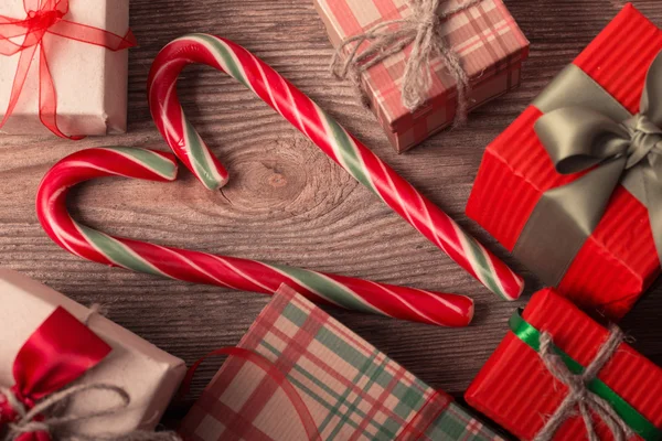 Baston şekerler kalp ve ahşap tahta üzerinde hediyeler — Stok fotoğraf