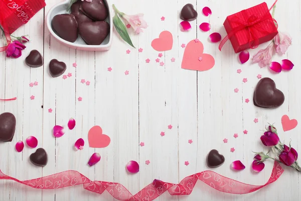 Valentinstag-Geschenkbox und rote Herzformen auf weißem Holzbrett — Stockfoto