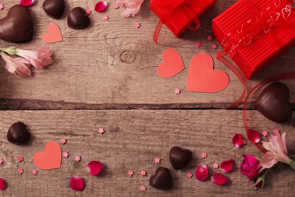 Caja de regalo de San Valentín y formas de corazón rojo en tablero de madera —  Fotos de Stock