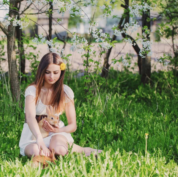 Belle jeune femme avec des lapins dans le jardin — Photo